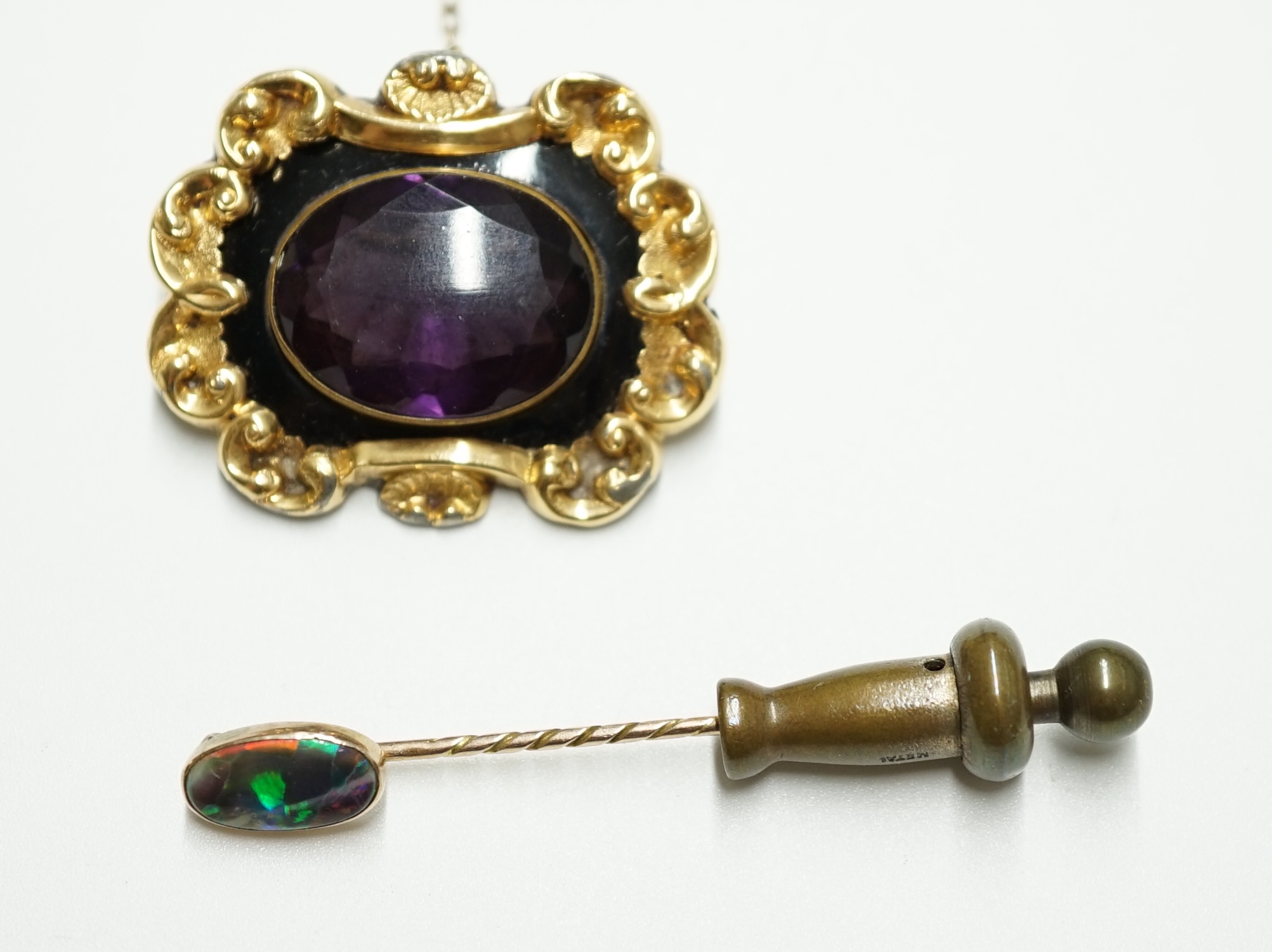 A Victorian gold plated and single stone oval amethyst paste set mourning brooch, 34mm, together with a yellow metal and black opal set stick pin. Condition - poor to fair